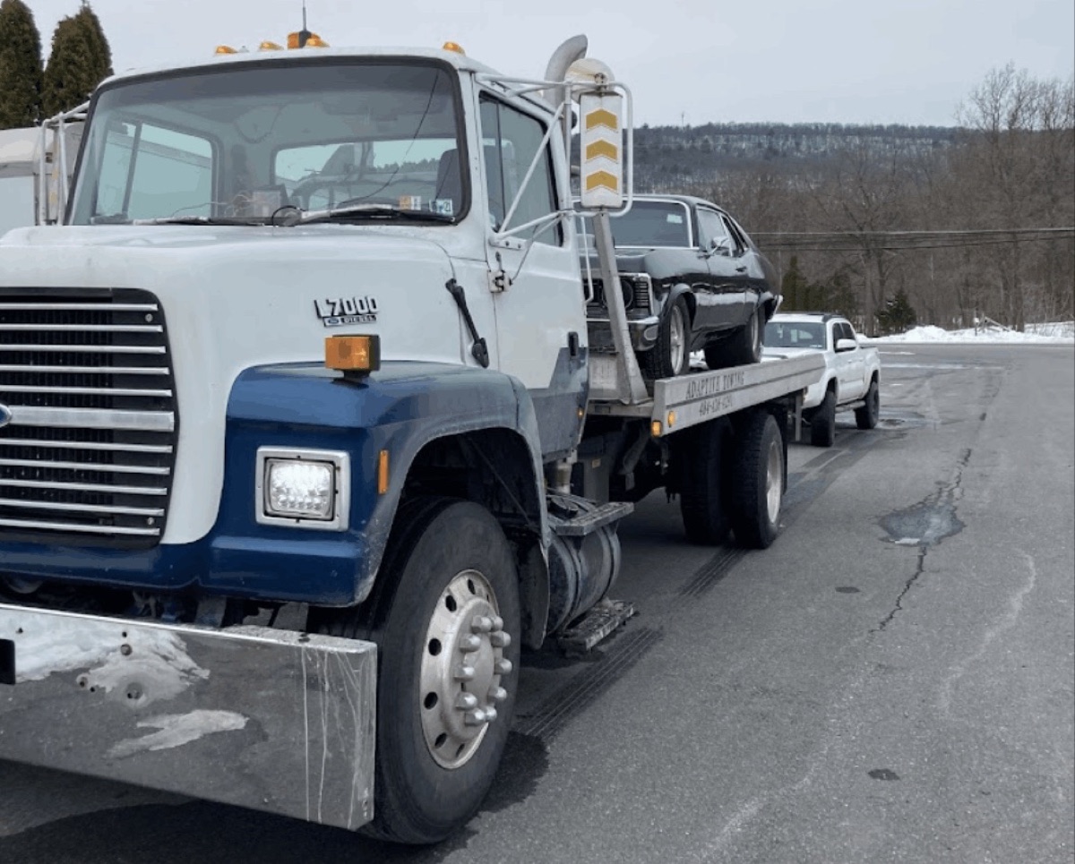 Huth Auto Services flatbed tow truck loading a vehicle